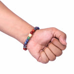 Hand wearing a colorful beaded bracelet on a white background