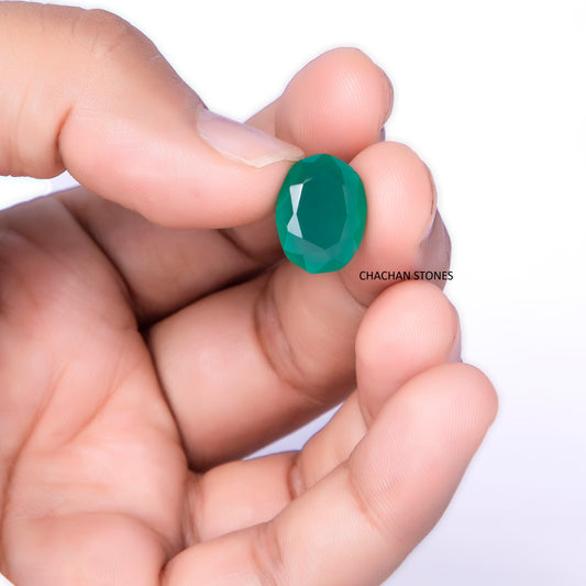 Hand holding a green gemstone with 'Chachan Stones' branding on a white background