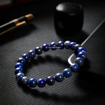 Blue beaded bracelet on a dark textured surface with 'CHACHAN STONES' branding.