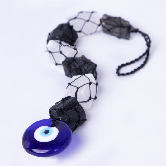 Necklace with blue evil eye pendant and black and white beads on a white background