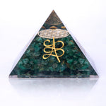 Triangular green stone pyramid with gold symbol on a white background
