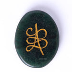Green stone with gold symbol on a white background