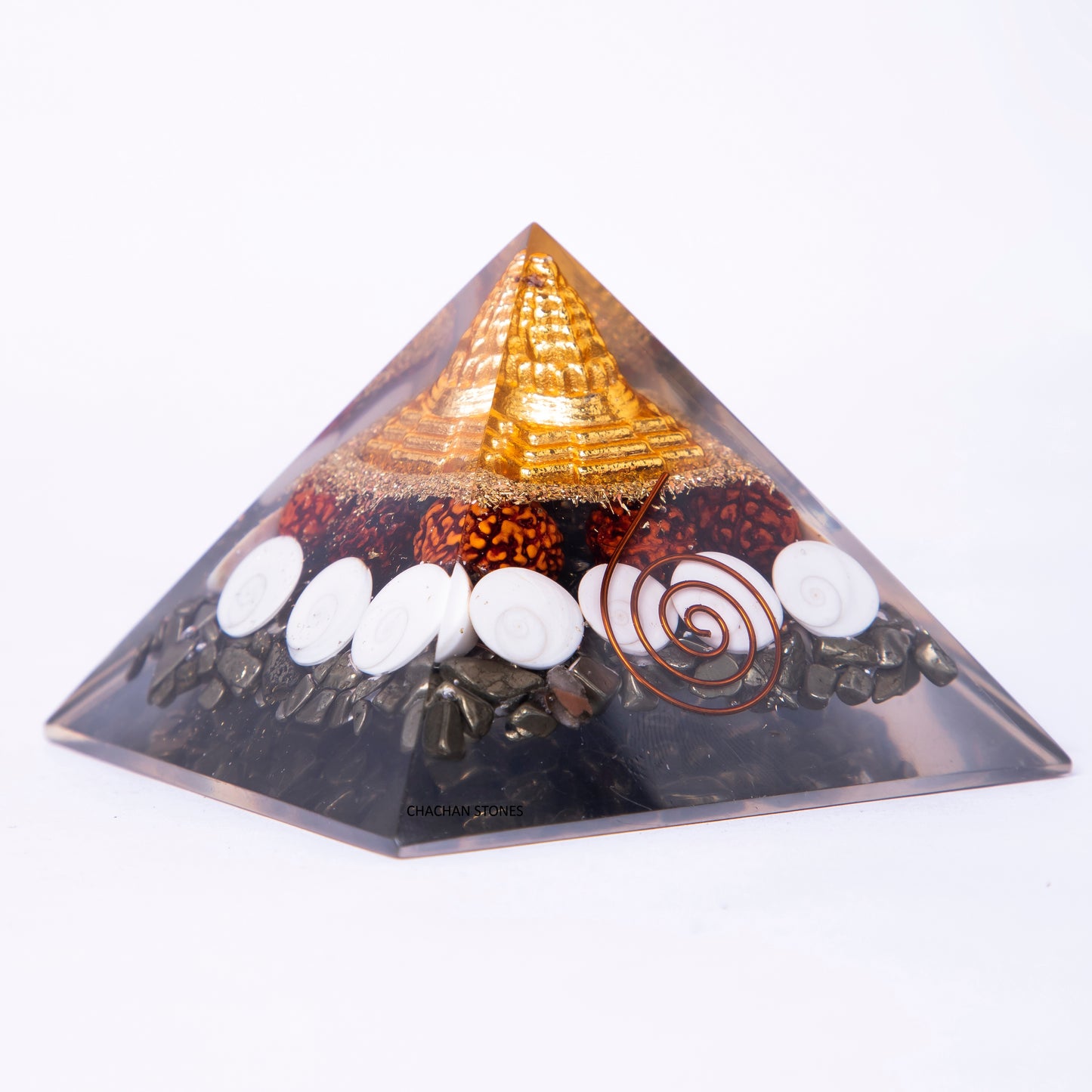 Pyramid-shaped object with stones and a spiral design on a white background