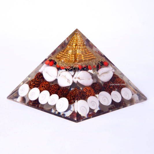 Pyramid-shaped crystal orgone with various stones on a white background