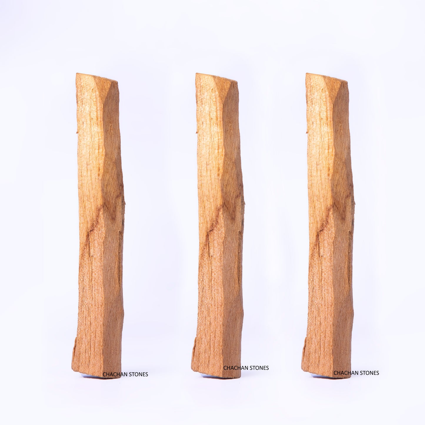 Three Palo-santo-wood-stick of different lengths on a white background
