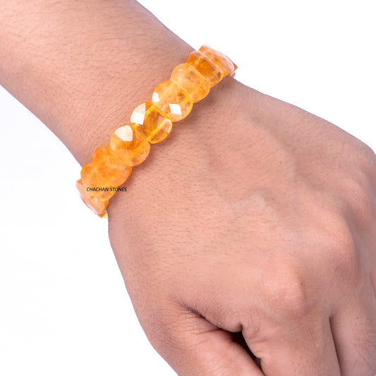 Orange beaded bracelet on a wrist with a plain background