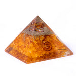Pyramid-shaped crystal with spiral designs on a white background