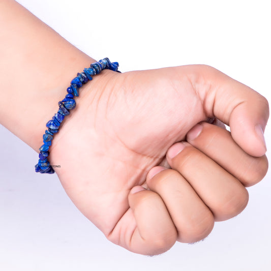 Hand wearing a blue beaded bracelet on a white background