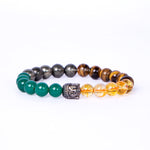 Beaded bracelet with green, black, and yellow beads on a white background