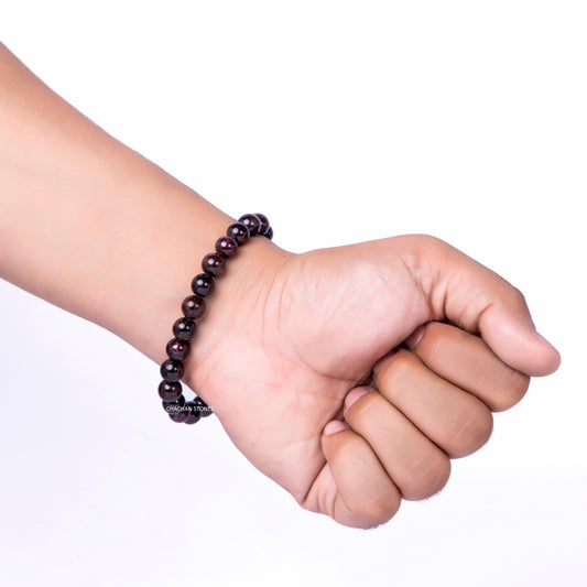 Hand wearing a bracelet on a white background
