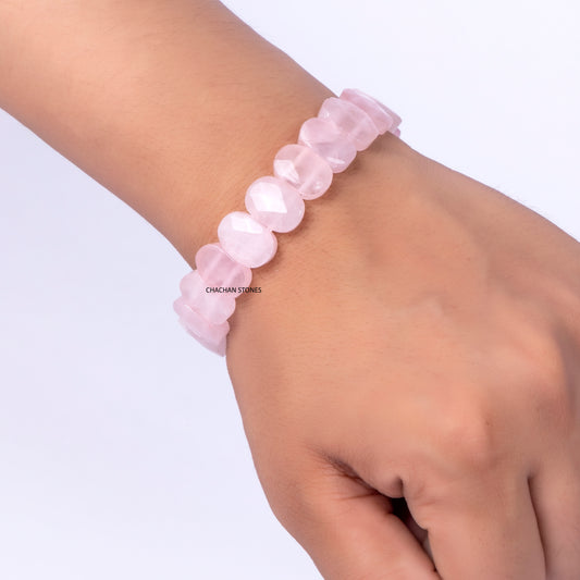 Pink beaded bracelet on a wrist against a white background